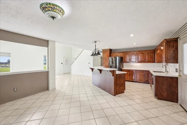 a kitchen with stainless steel appliances kitchen island granite countertop a sink and a stove