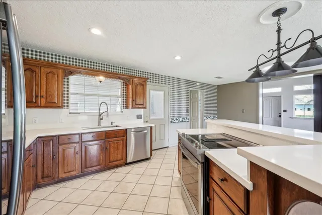 a kitchen with stainless steel appliances granite countertop a sink and stove top oven