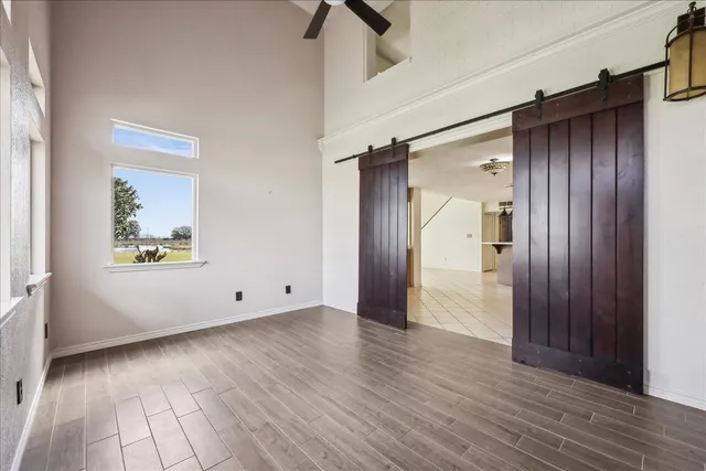 a view of an empty room with wooden floor and a window