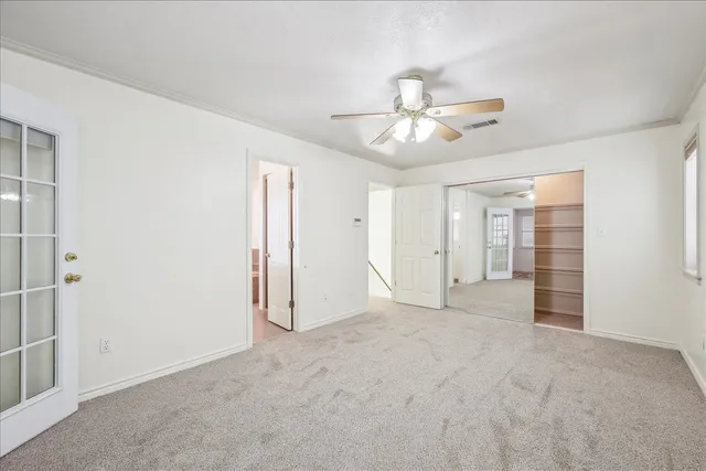 an empty room with closet and windows