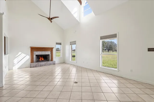 a view of an empty room with window and fire place