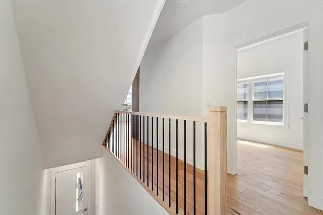 a view of a hallway with wooden floor and a window