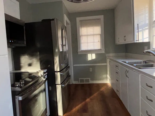 a kitchen with a refrigerator stove and cabinets