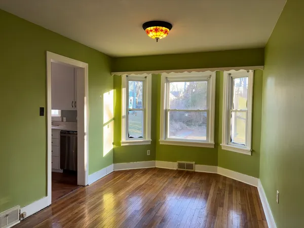 an empty room with wooden floor and a window