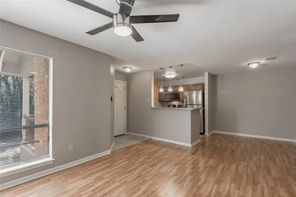 a view of a kitchen with wooden floor and a ceiling fan
