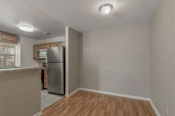 a view of a refrigerator in kitchen and wooden floor