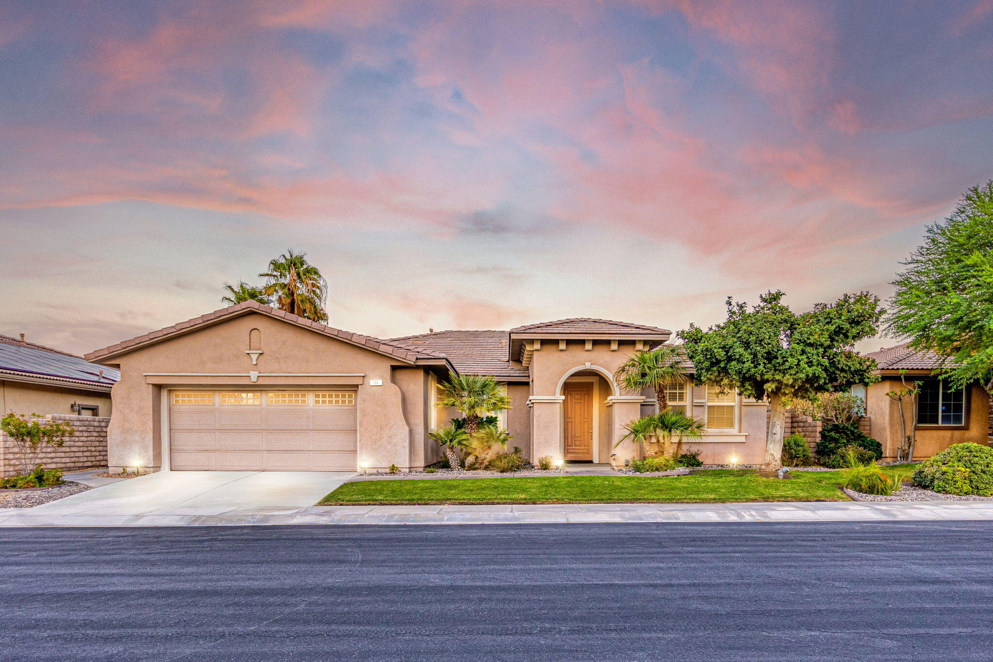 a front view of a house with a garden and garage