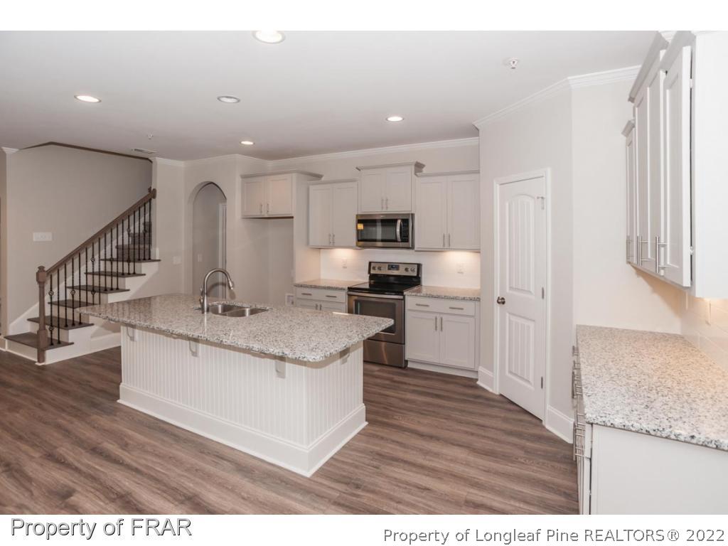 160 Winged Foot Road Pinehurst, NC 28374 - Photo 15 of 35 a kitchen with stainless steel appliances granite countertop a sink stove and refrigerator