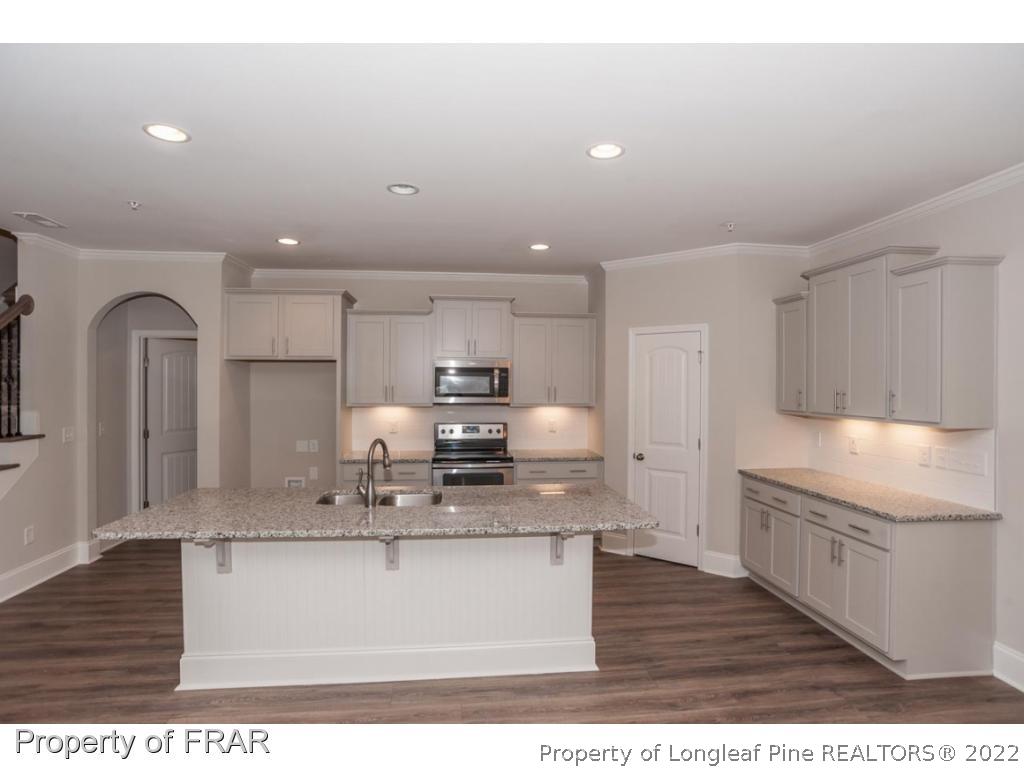 160 Winged Foot Road Pinehurst, NC 28374 - Photo 16 of 35 a kitchen with kitchen island a sink stainless steel appliances and cabinets