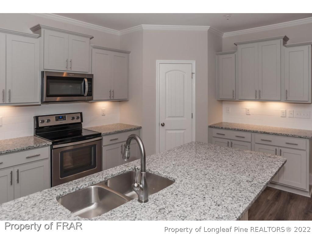 160 Winged Foot Road Pinehurst, NC 28374 - Photo 19 of 35 a kitchen with kitchen island a sink stainless steel appliances and cabinets