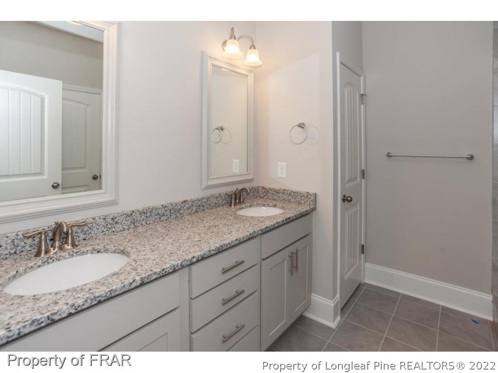 160 Winged Foot Road Pinehurst, NC 28374 - Photo 24 of 35 a bathroom with a granite countertop sink and a mirror