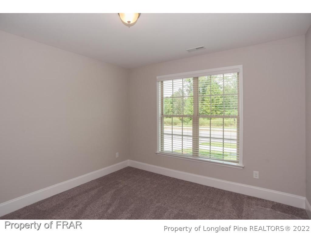 160 Winged Foot Road Pinehurst, NC 28374 - Photo 28 of 35 an empty room with wooden floor and windows