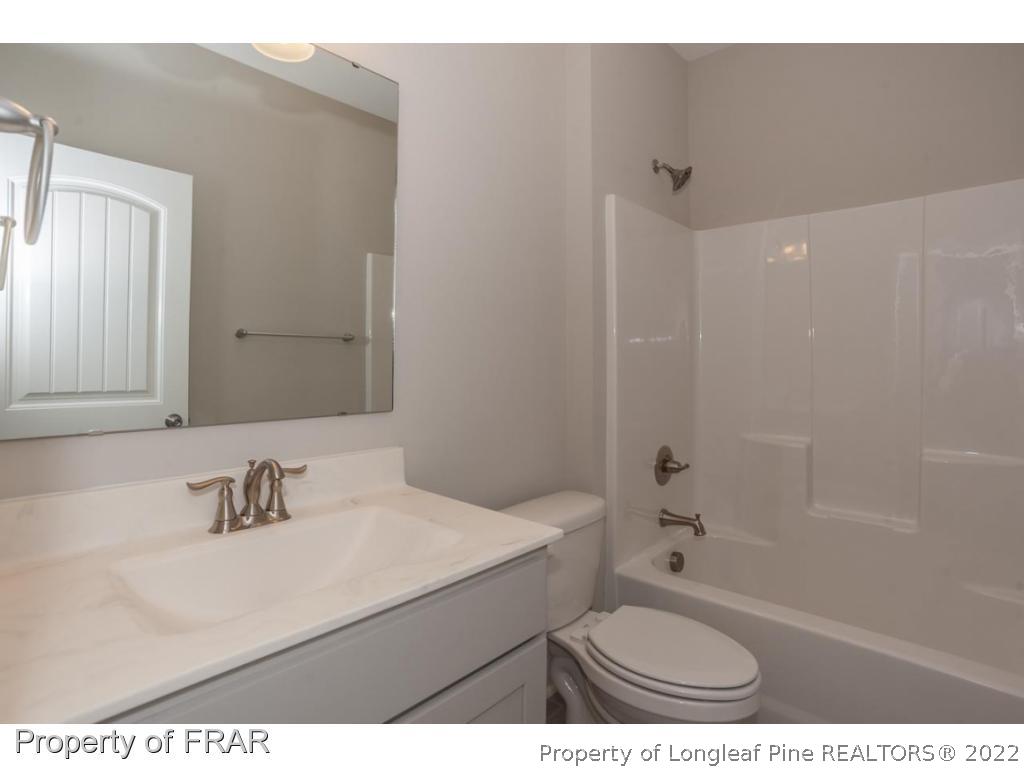 160 Winged Foot Road Pinehurst, NC 28374 - Photo 30 of 35 a bathroom with a sink toilet a mirror and shower