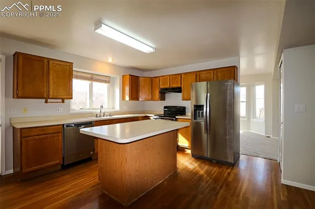 a kitchen with stainless steel appliances granite countertop a stove a sink and a refrigerator