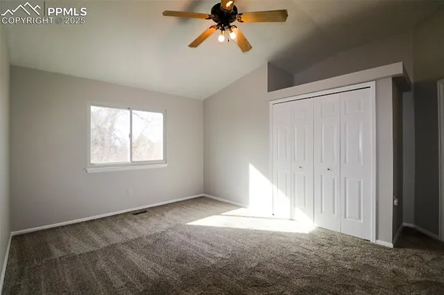 a view of an empty room with a ceiling fan