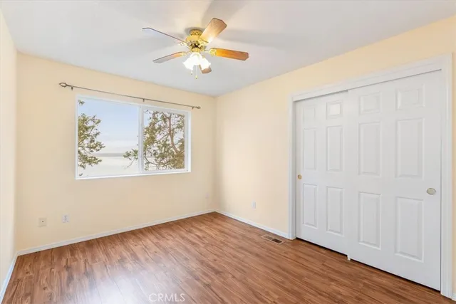 an empty room with wooden floor and window