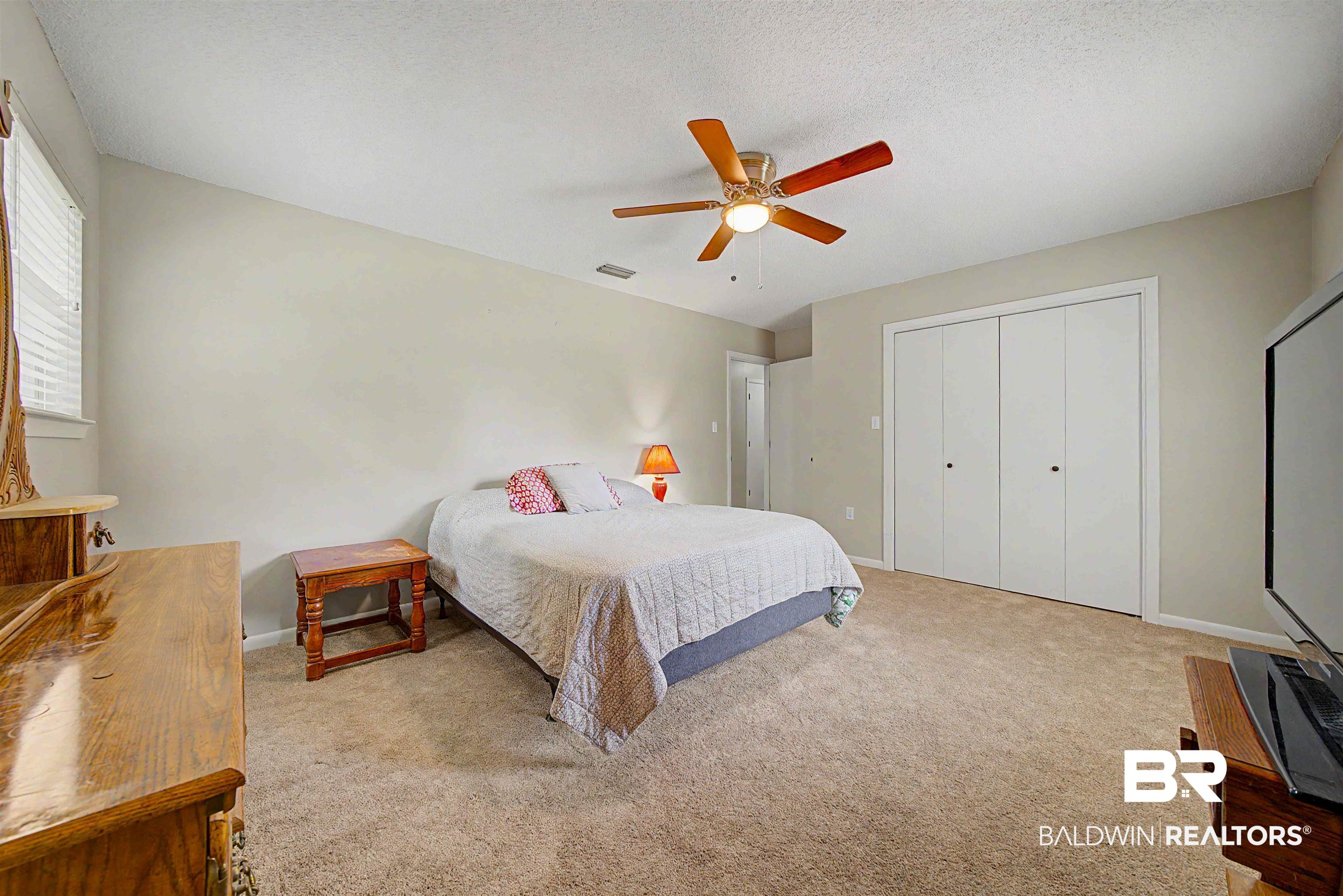 22963 Highway 98 Foley, AL 36535 - Photo 24 of 52 Carpeted interior space featuring a ceiling fan with light fixture, light-toned walls, and a window with blinds