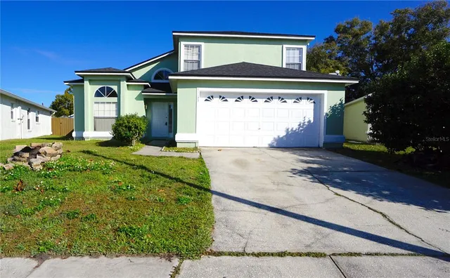 a front view of a house with a yard and garage