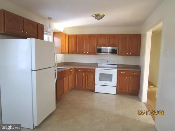 a kitchen with a refrigerator sink and cabinets