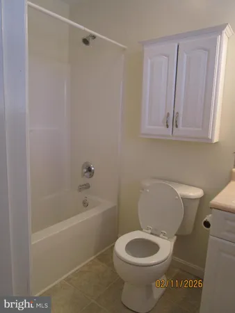 a white toilet sitting next to a bath tub