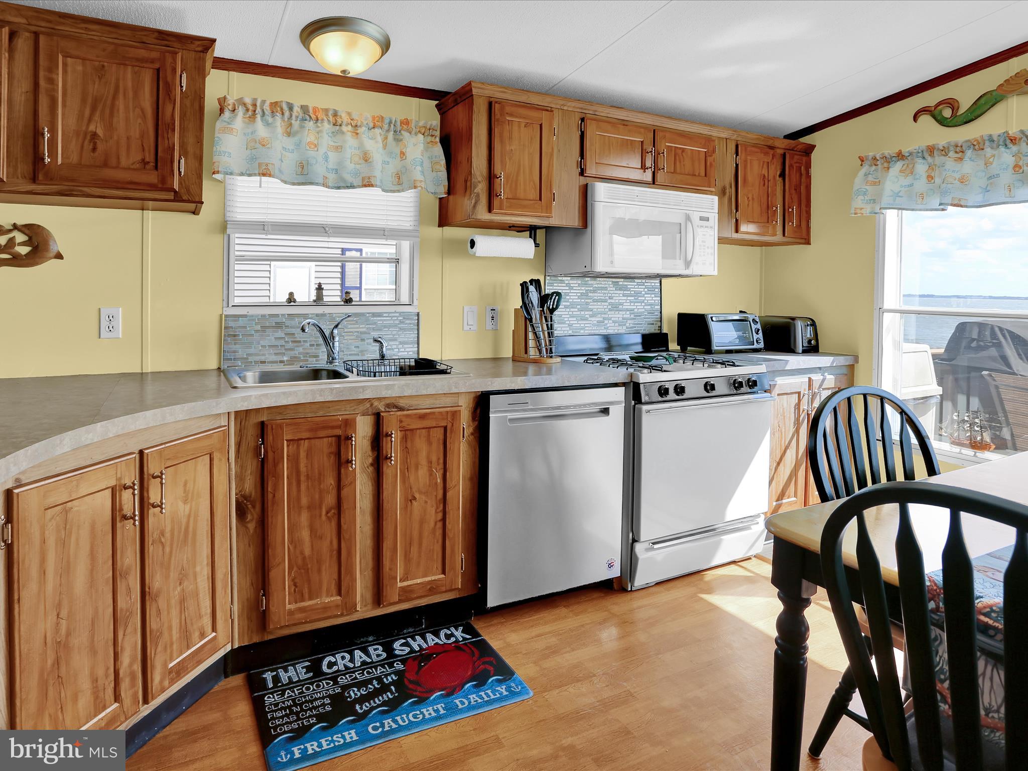 27412 Grove Circle Road Millsboro, DE 19966 - Photo 18 of 43 a kitchen with stainless steel appliances granite countertop a stove a sink dishwasher and cabinets with wooden floor