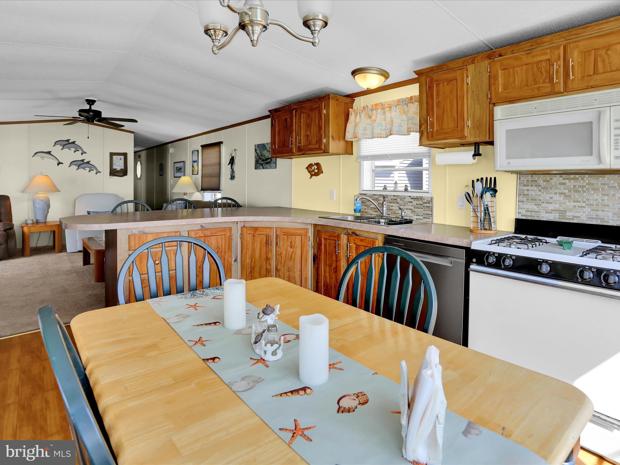 27412 Grove Circle Road Millsboro, DE 19966 - Photo 21 of 43 a kitchen with stainless steel appliances granite countertop a dining table chair and a refrigerator