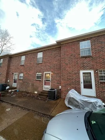 a view of a patio with couches table and chairs under an umbrella