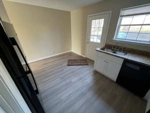 a kitchen with granite countertop a stove and wooden floor