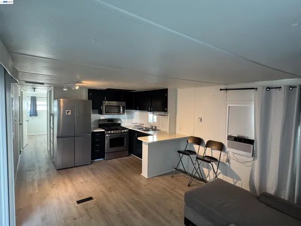 a kitchen with a refrigerator and a stove top oven