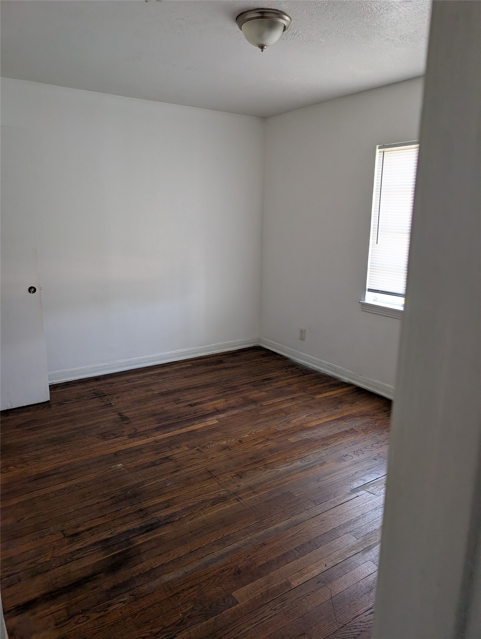109 East Parker Road Houston, TX 77076 - Photo 6 of 11 an empty room with wooden floor and windows