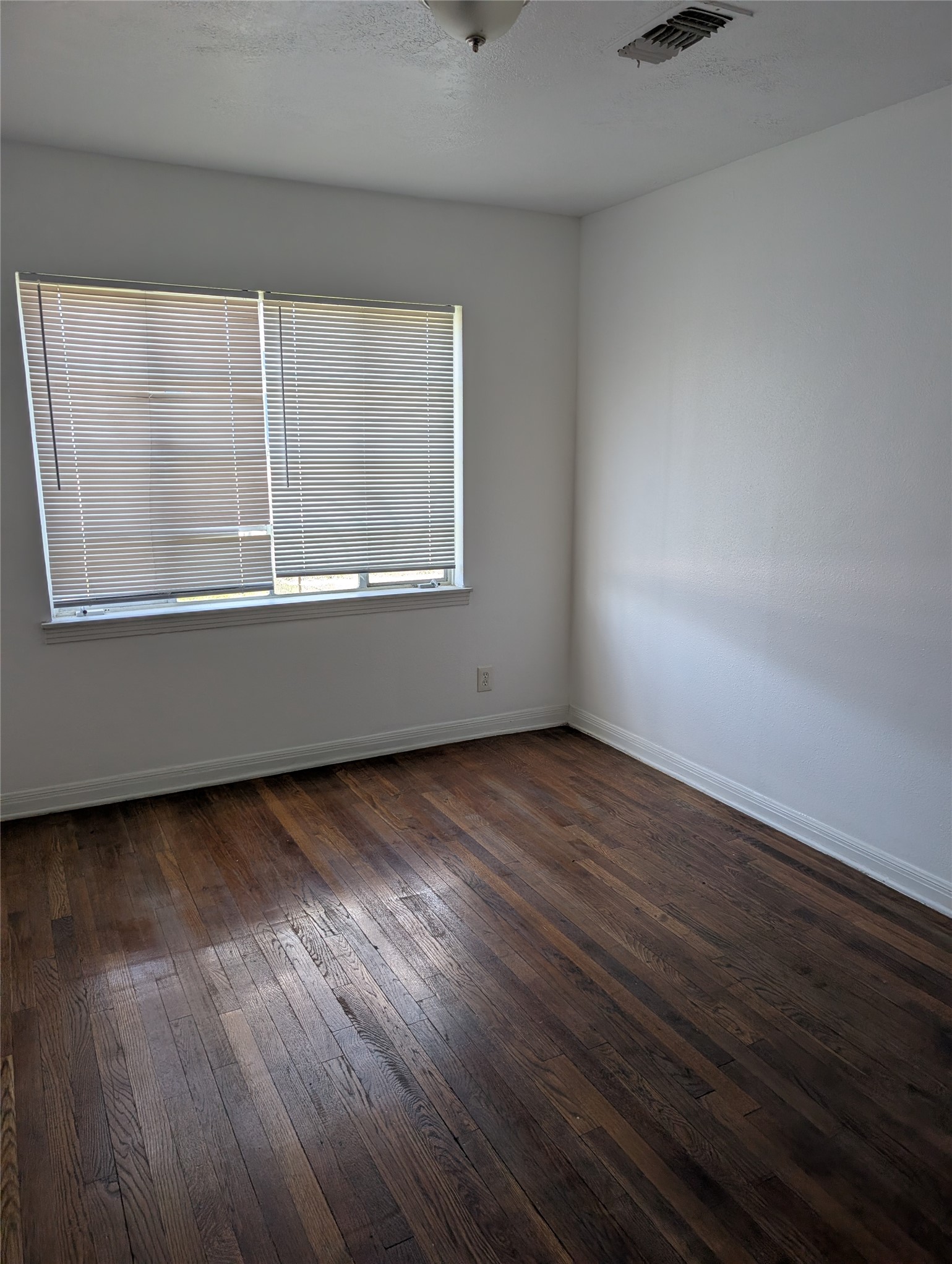 109 East Parker Road Houston, TX 77076 - Photo 7 of 11 an empty room with wooden floor and windows