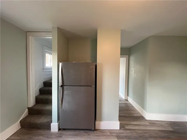 a view of a hallway with wooden floor and cabinets
