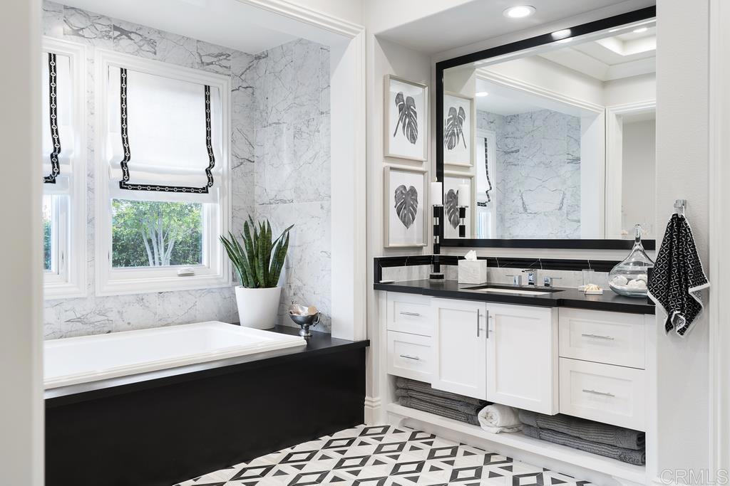 15527 Artesian Ridge San Diego, CA 92127 - Photo 17 of 32 a bathroom with a sink a mirror and a bathtub next to a window