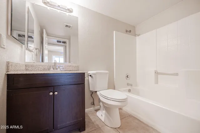 a bathroom with a granite countertop sink a toilet and a bathtub