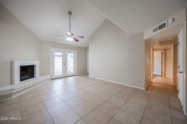 a view of an empty room with window and fire place