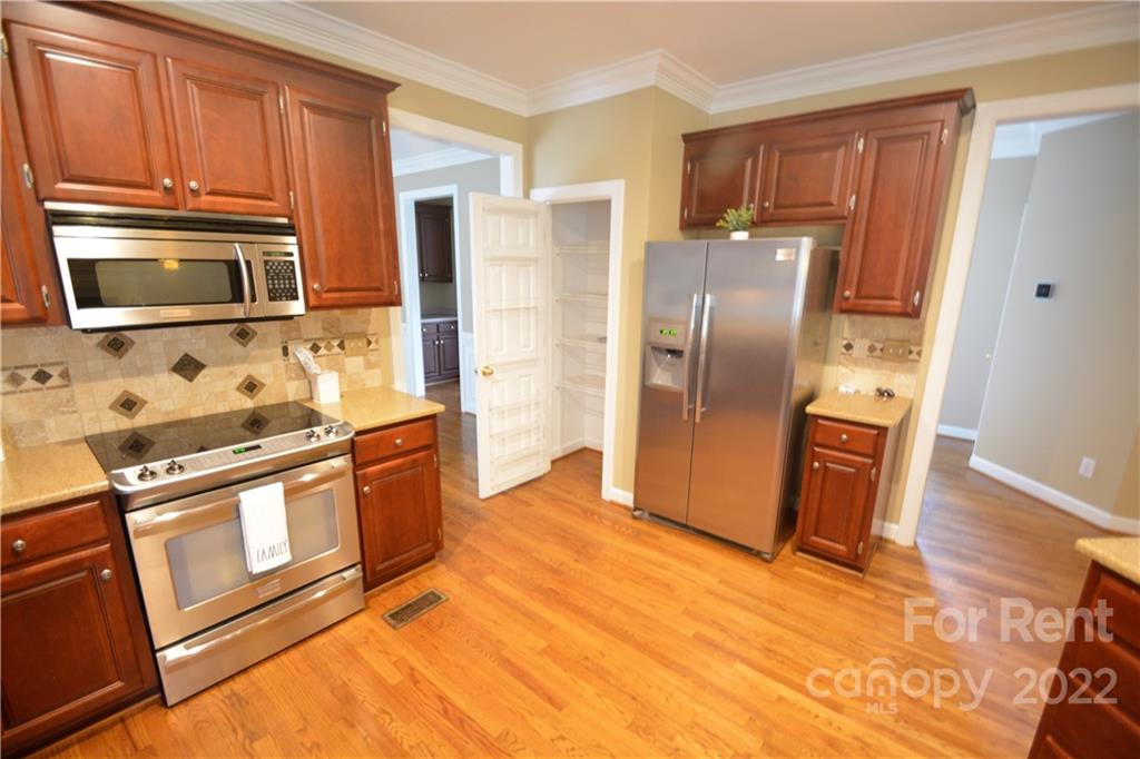 2127 Copperplate Road Charlotte, NC 28262 - Photo 11 of 37 a kitchen with stainless steel appliances granite countertop a refrigerator and a stove top oven
