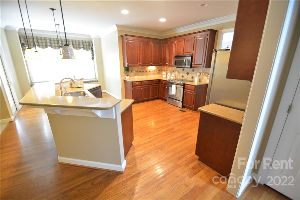 2127 Copperplate Road Charlotte, NC 28262 - Photo 12 of 37 a kitchen with stainless steel appliances granite countertop a refrigerator a sink a stove and a wooden floors