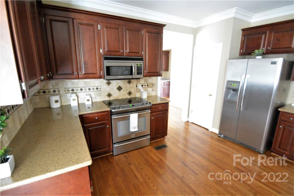 2127 Copperplate Road Charlotte, NC 28262 - Photo 14 of 37 a kitchen with stainless steel appliances granite countertop a refrigerator stove and sink