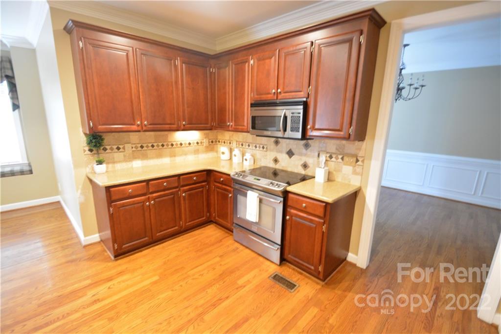 2127 Copperplate Road Charlotte, NC 28262 - Photo 18 of 37 a kitchen with stainless steel appliances granite countertop a stove a sink and a microwave