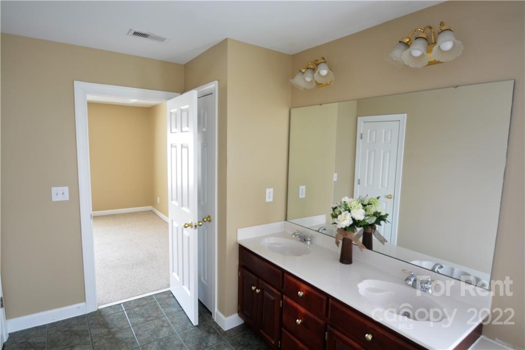 2127 Copperplate Road Charlotte, NC 28262 - Photo 33 of 37 a bathroom with a sink vanity and a mirror