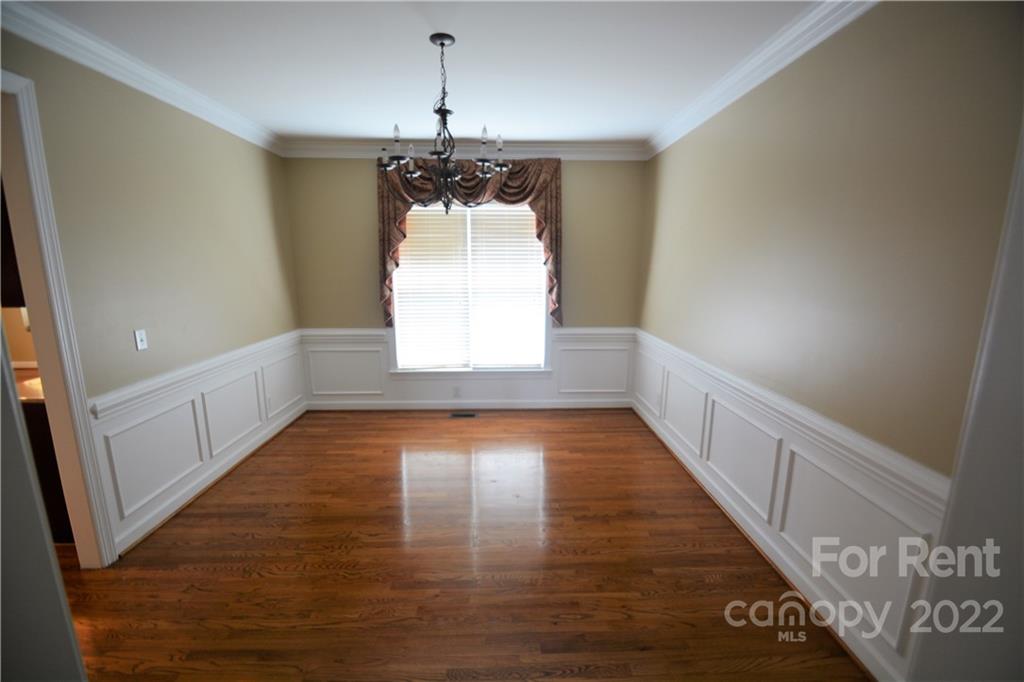 2127 Copperplate Road Charlotte, NC 28262 - Photo 8 of 37 a view of a hallway with wooden floor and chandelier