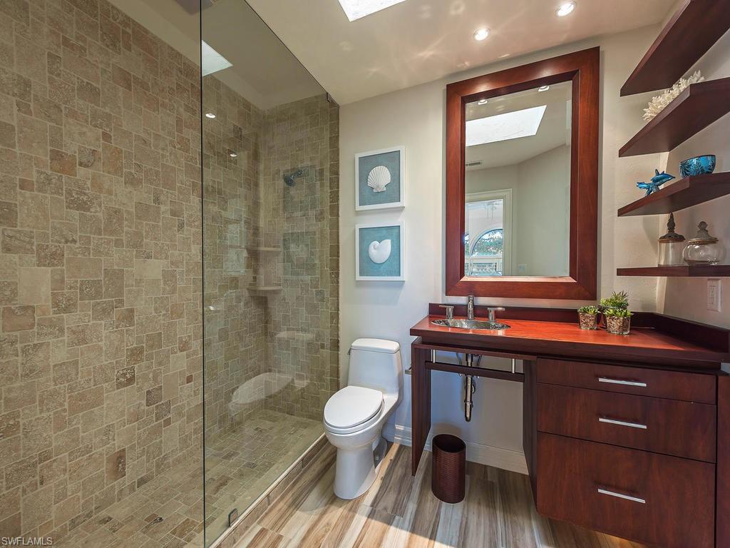 4217 Crayton Road Naples, FL 34103 - Photo 13 of 22 a bathroom with a sink a toilet and shower