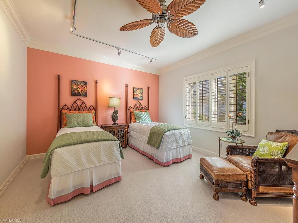 4217 Crayton Road Naples, FL 34103 - Photo 14 of 22 a spacious bedroom with two beds and a chandelier