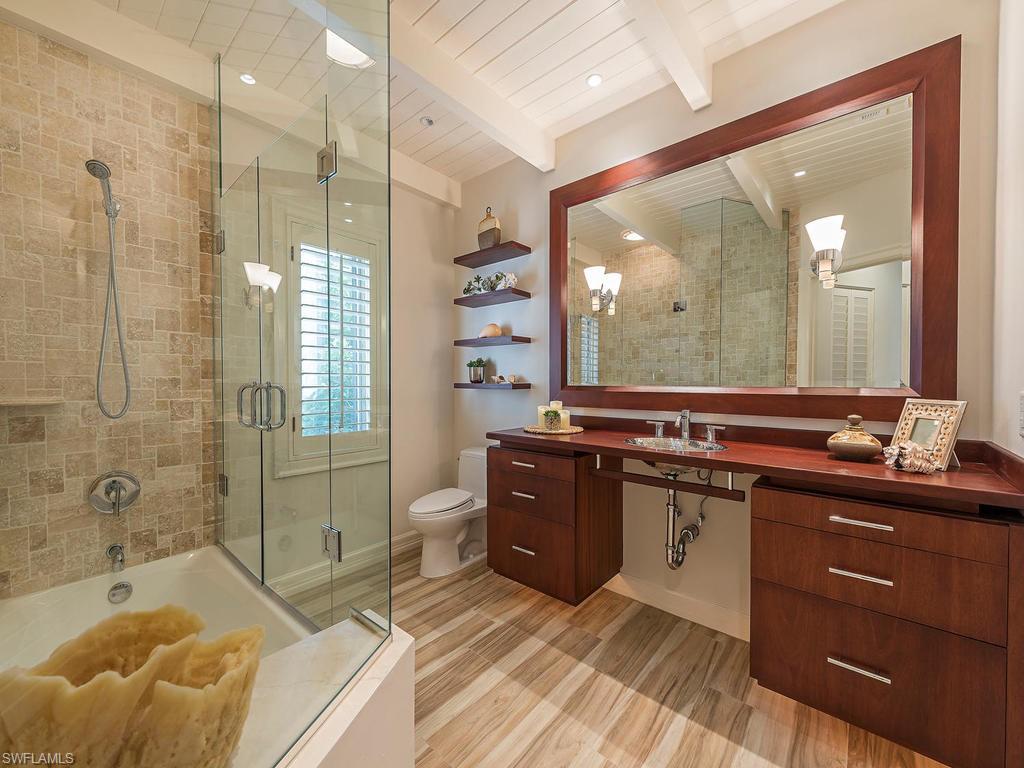 4217 Crayton Road Naples, FL 34103 - Photo 15 of 22 a spacious bathroom with a tub sink shower and mirror