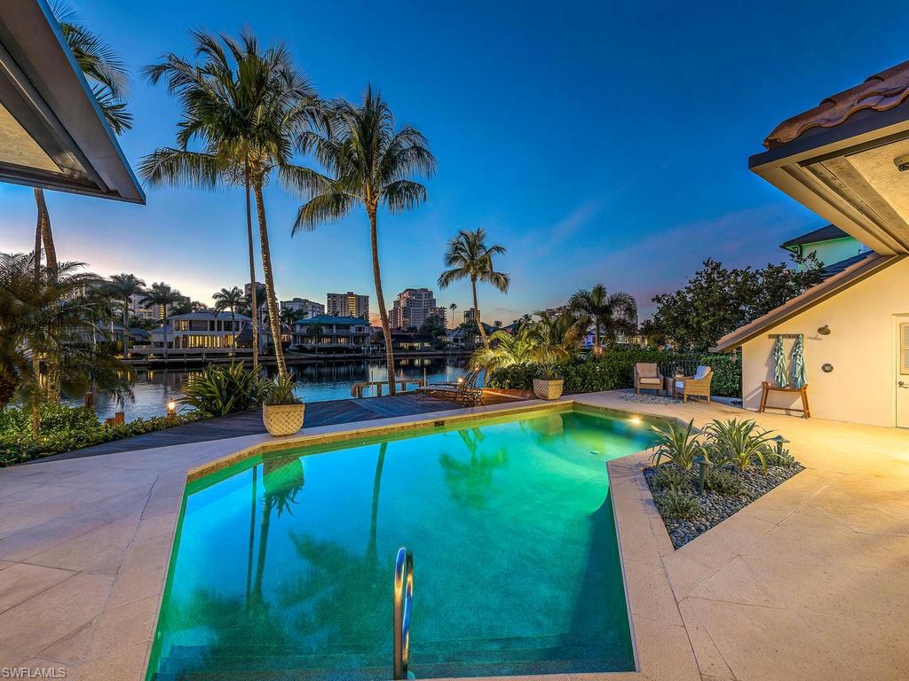 4217 Crayton Road Naples, FL 34103 - Photo 20 of 22 a view of a swimming pool with a garden and plants