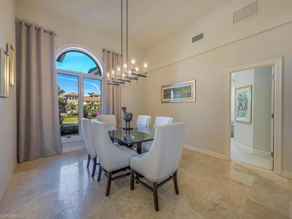 4217 Crayton Road Naples, FL 34103 - Photo 6 of 22 a dining room with furniture a chandelier and wooden floor