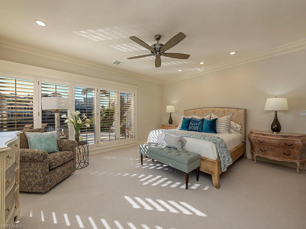4217 Crayton Road Naples, FL 34103 - Photo 9 of 22 a spacious bedroom with a bed and a couch