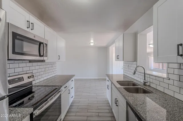 a kitchen with granite countertop a sink and stove top oven