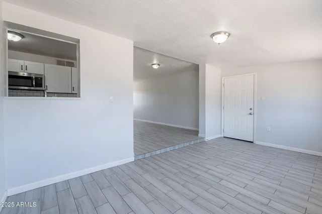 an empty room with wooden floor and mirror