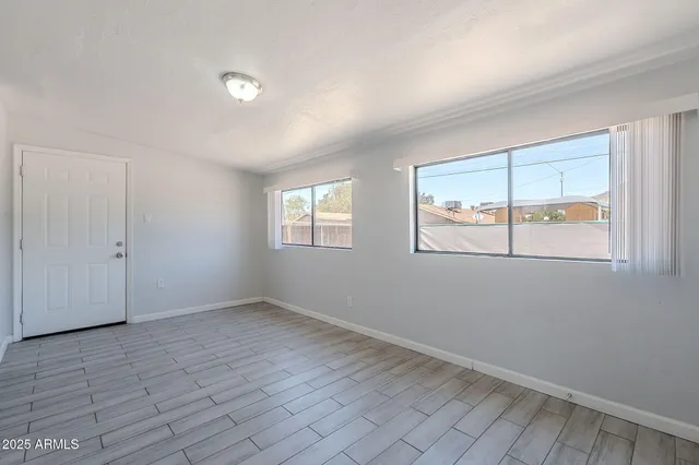 wooden floor in an empty room with a window